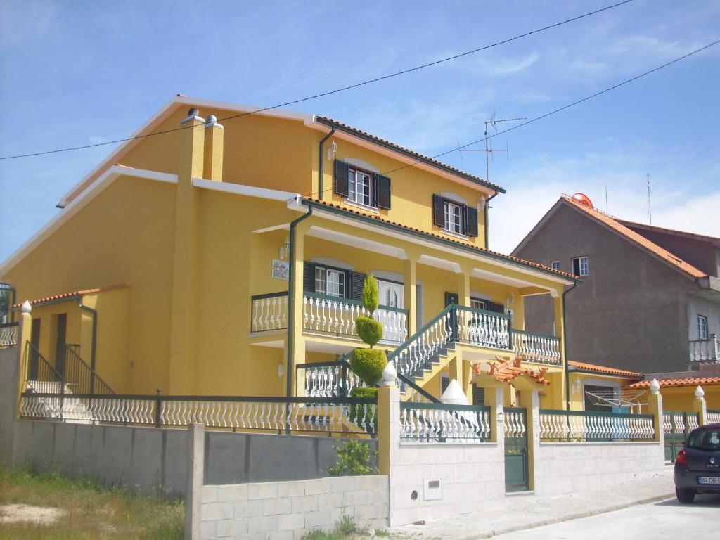 a yellow house with balconies on a street at Casa De Ferias Santos in Aguiar da Beira