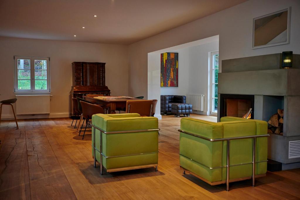 a living room with a fireplace and a table and chairs at Unterpetersbächlerhof in Fischbach bei Dahn