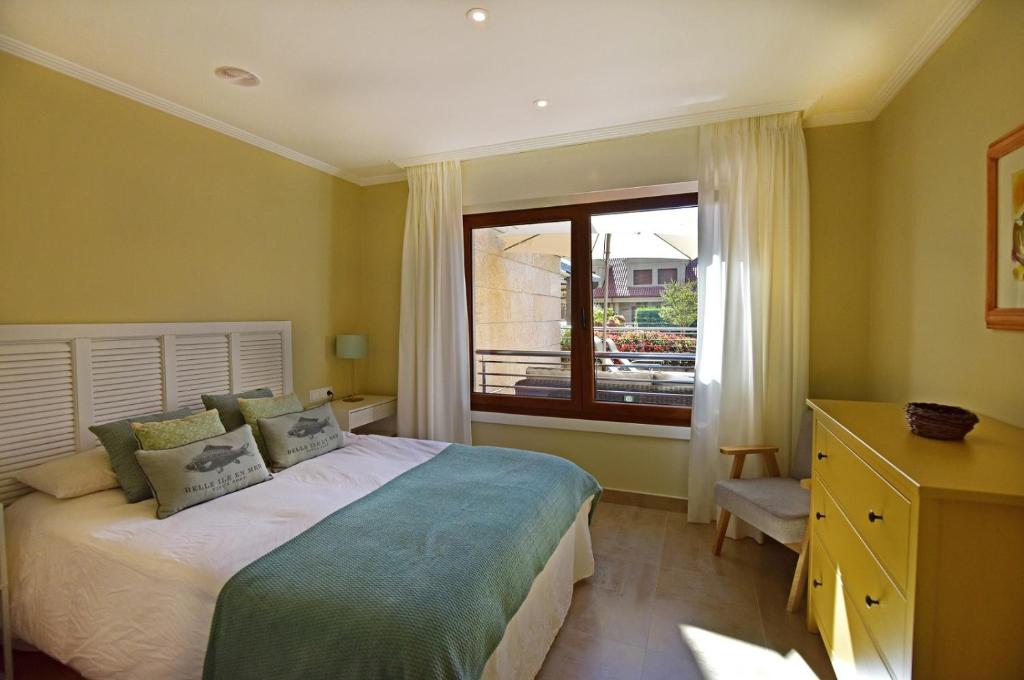 Un pat sau paturi într-o cameră la New apartamento Bajo en Isla de la Toja.