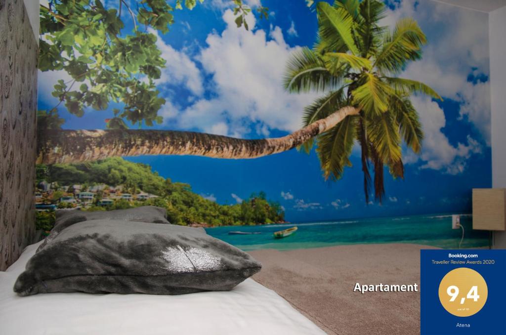 a bedroom with a tropical beach with a palm tree mural at Atena in Rumia