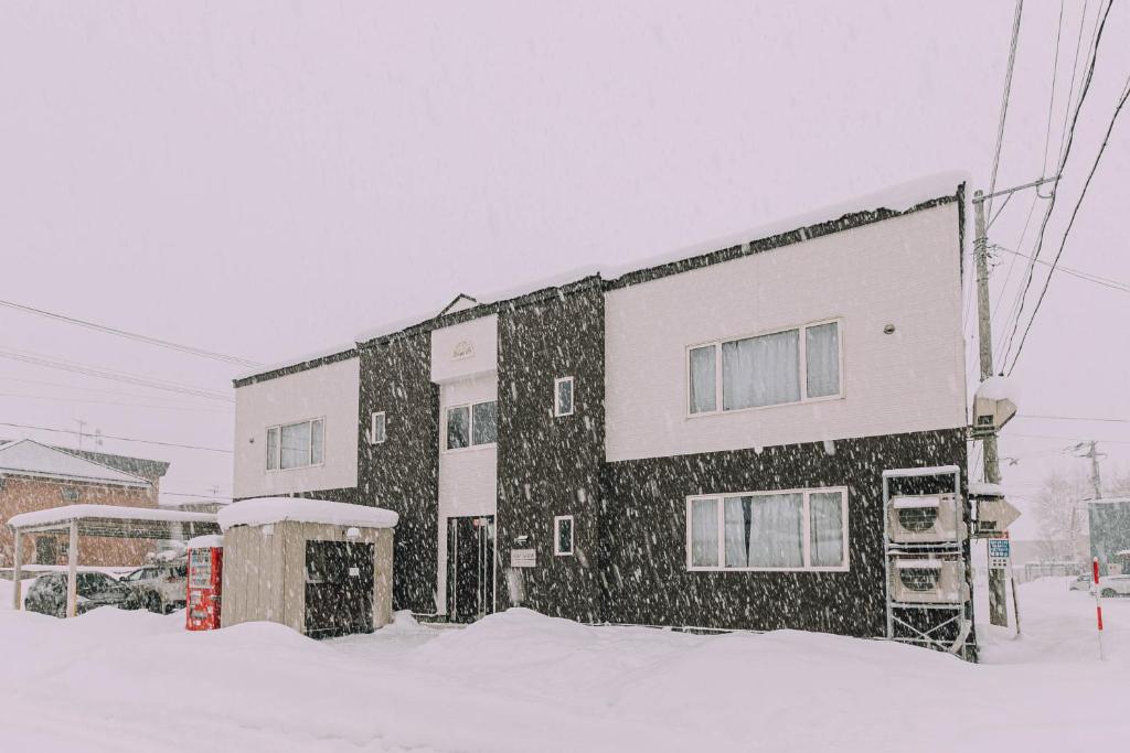 um edifício coberto de neve na frente em Stay In Biei em Biei
