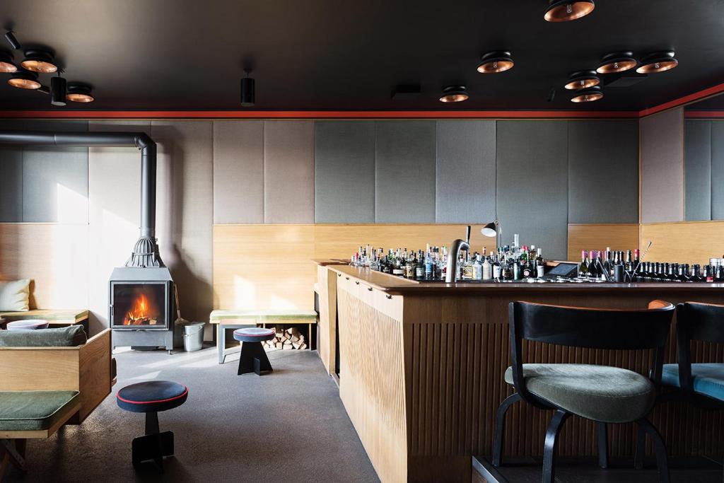 a restaurant with a bar and a fireplace at The Flushing Meadows Hotel in Munich