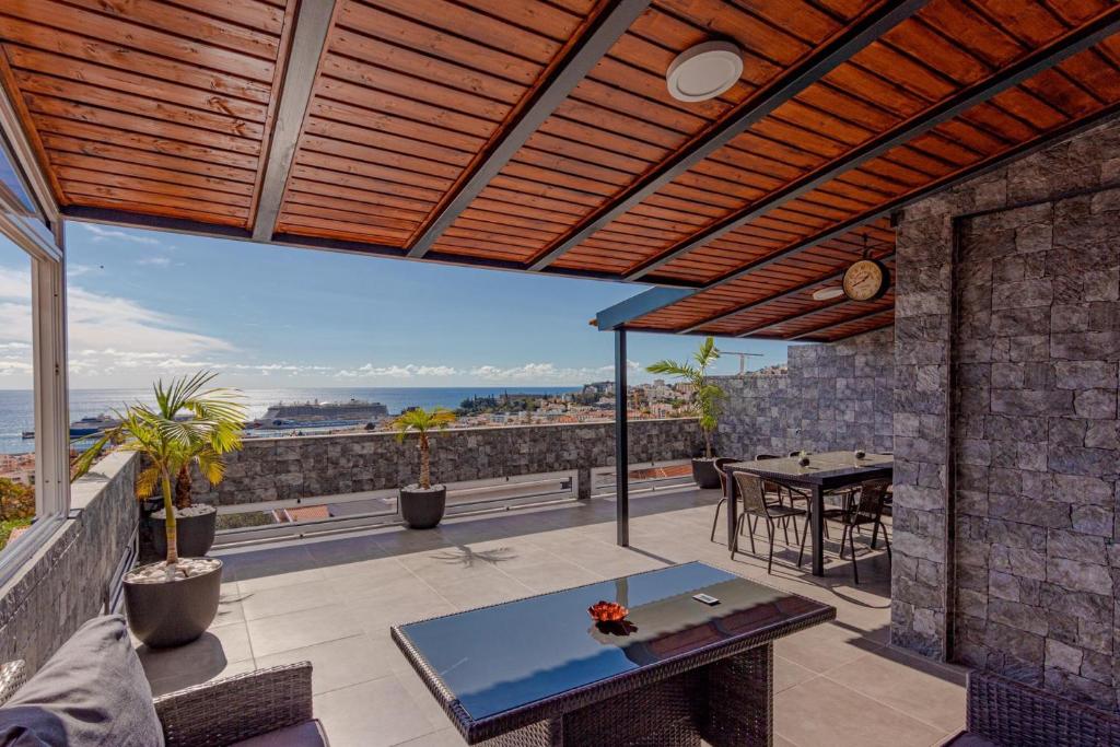 patio ze stołem i widokiem na ocean w obiekcie Flowers Island house 2 w Funchal