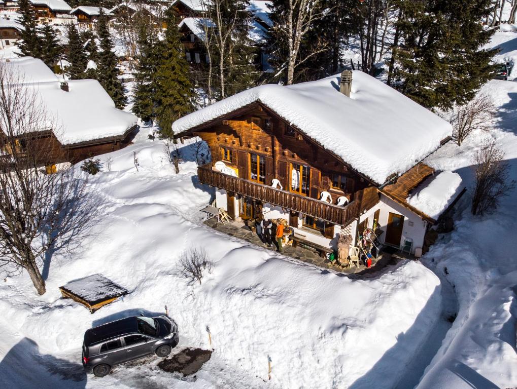 an aerial view of a log cabin in the snow at le castor in Morgins