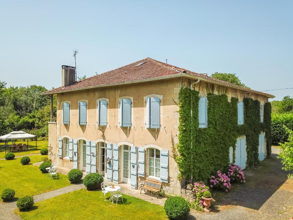 Una casa grande con hiedra a un lado. en Appart'Hôtel Bellevue, en Bayona