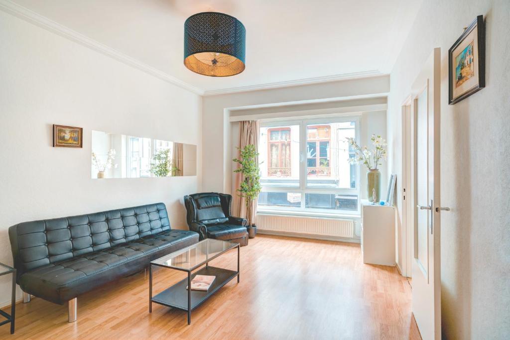 un soggiorno con divano e sedia di Lucky Lambert Apartment ad Anversa