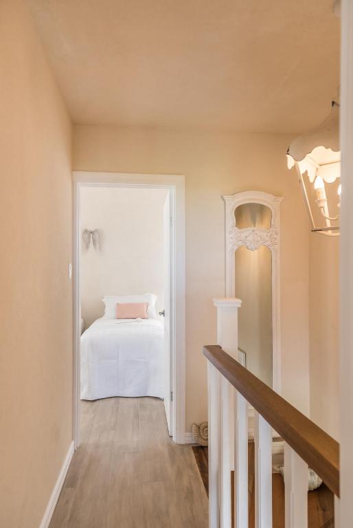 a bedroom with a white bed and a staircase at West Rock Villas in Saint James