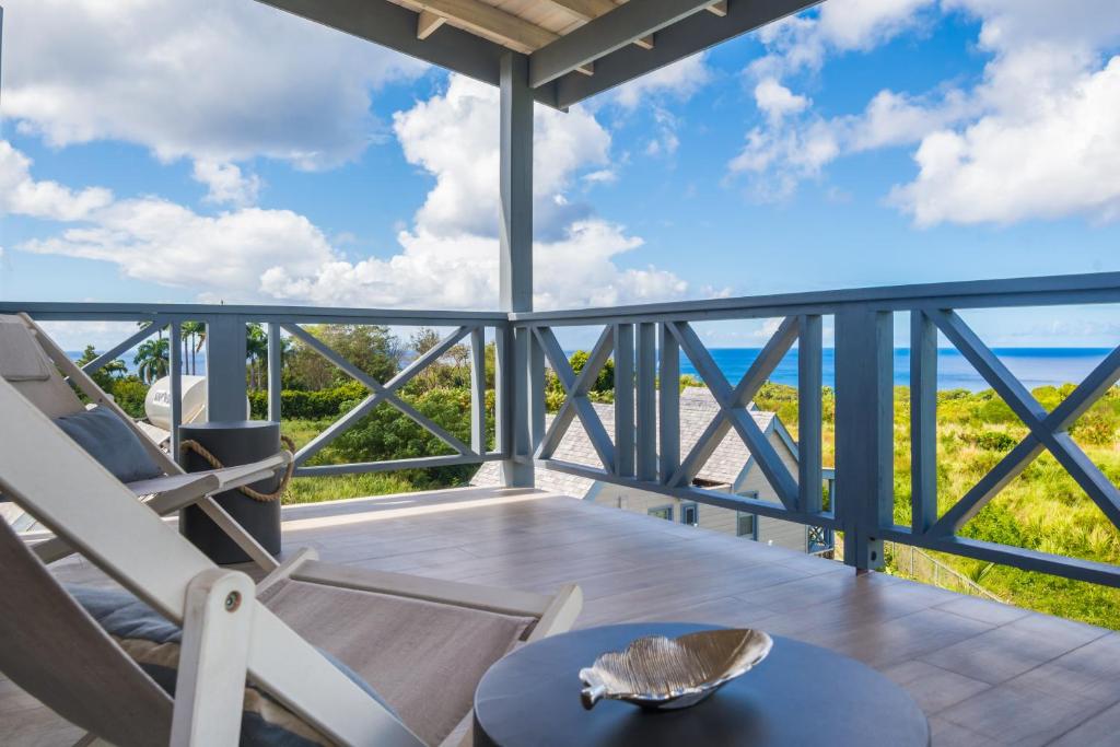 a balcony with a table and chairs and the ocean at West Rock Villas in Saint James