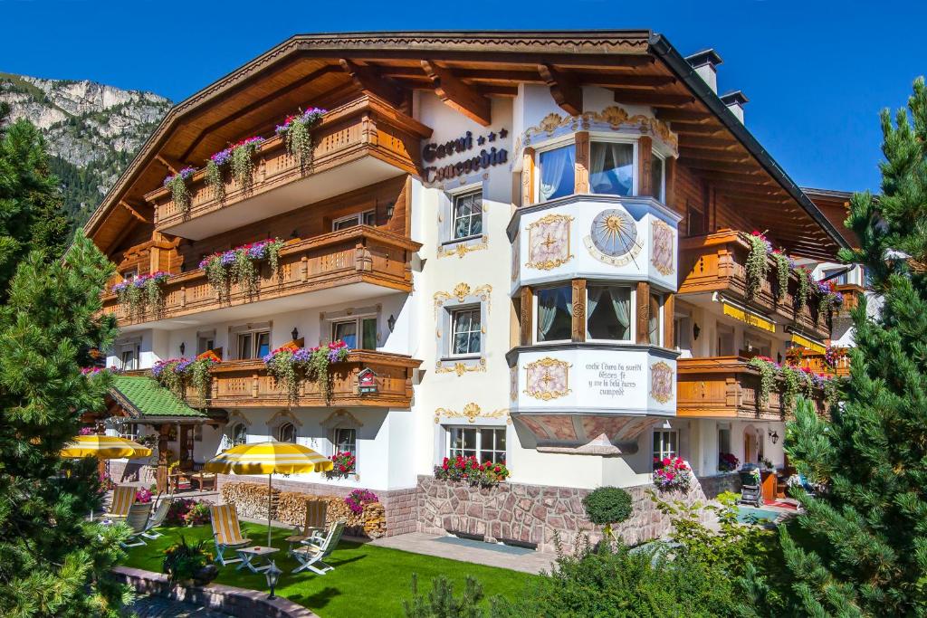 a hotel in the mountains with flowers on the balconies at Hotel Garni Concordia - Dolomites Home in Selva di Val Gardena