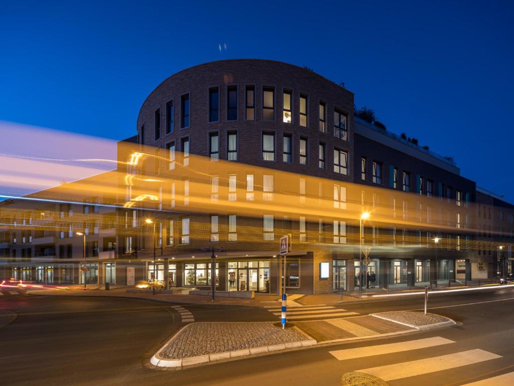 - un bâtiment de nuit avec une rue en face dans l'établissement RS-HOTEL - smart & modern Hotel Apartments, à Brühl