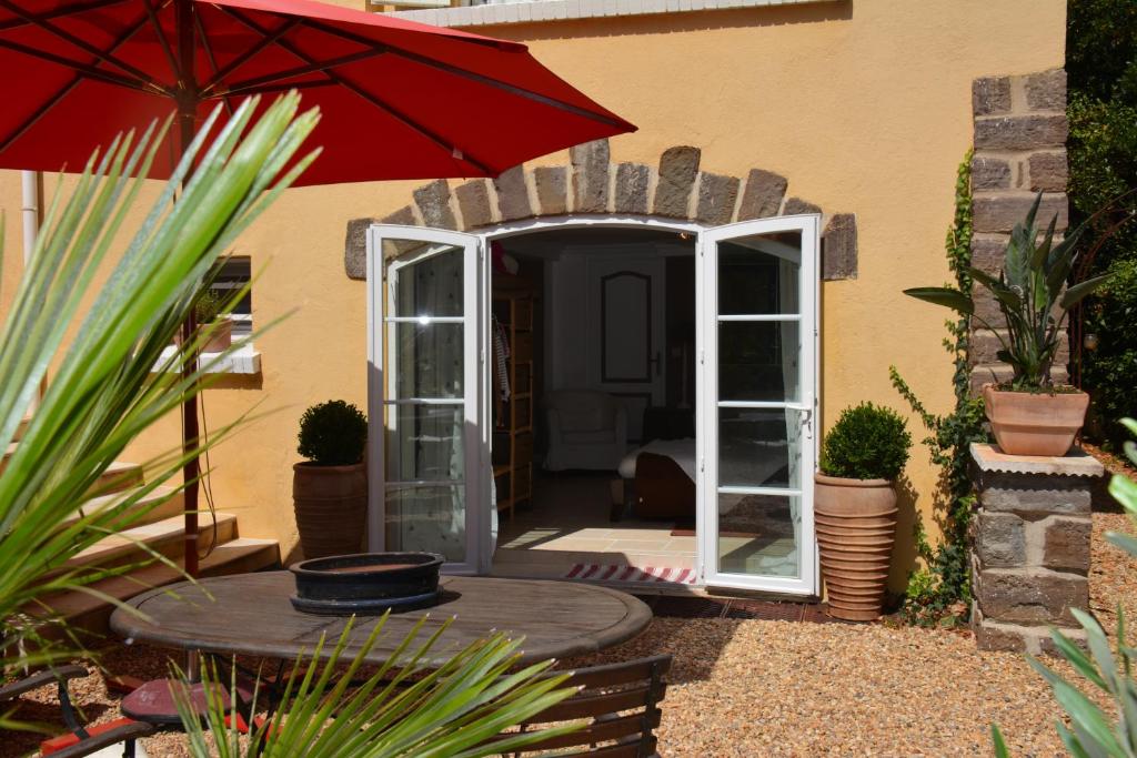 d'une terrasse avec une table et un parasol rouge. dans l'établissement La Javanaise, à Saint-Aygulf