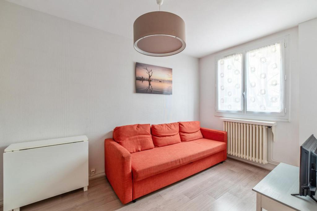 ein Wohnzimmer mit einem roten Sofa und einem Fenster in der Unterkunft Modern and bright flat in Monplaisir district Lyon center - Welkeys in Lyon