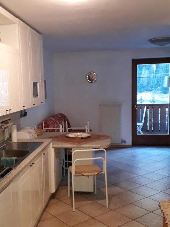 uma cozinha com um balcão e uma mesa com uma cadeira em Le betulle - 022147-AT-050930 em Predazzo