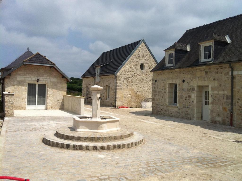 a courtyard with a statue in front of two buildings at Gîtes De Saint Rémy in Villers-Cotterêts