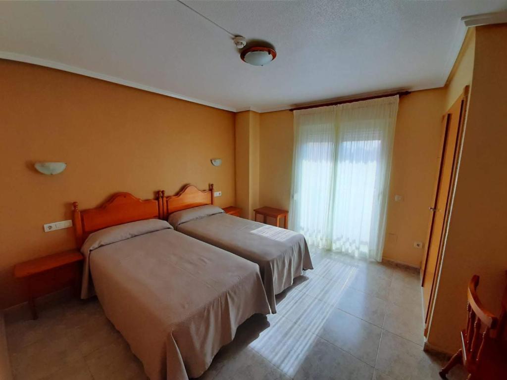 Un dormitorio con una cama grande y una ventana en Hotel Cano, en Torrevieja