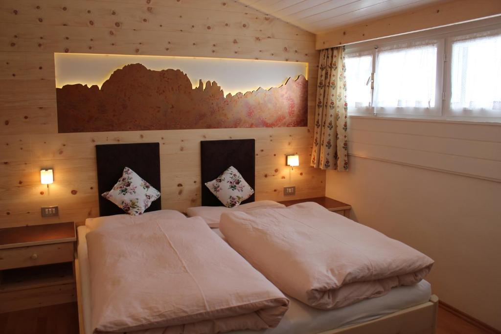 ein Schlafzimmer mit 2 Betten und einem Wandgemälde in der Unterkunft Berggasthof Pension Pfitscher in Unsere Liebe Frau im Walde
