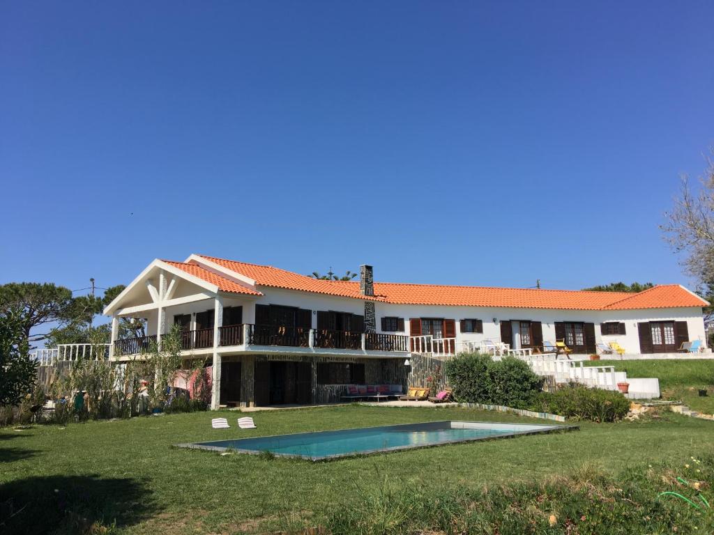 a large house with a swimming pool in the yard at Elemental Ericeira in Ericeira