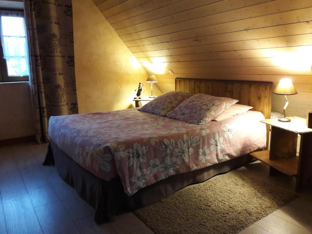um quarto com uma cama num quarto com paredes de madeira em Chambres d'hôtes "La Bouill'hôte" em Langensoultzbach