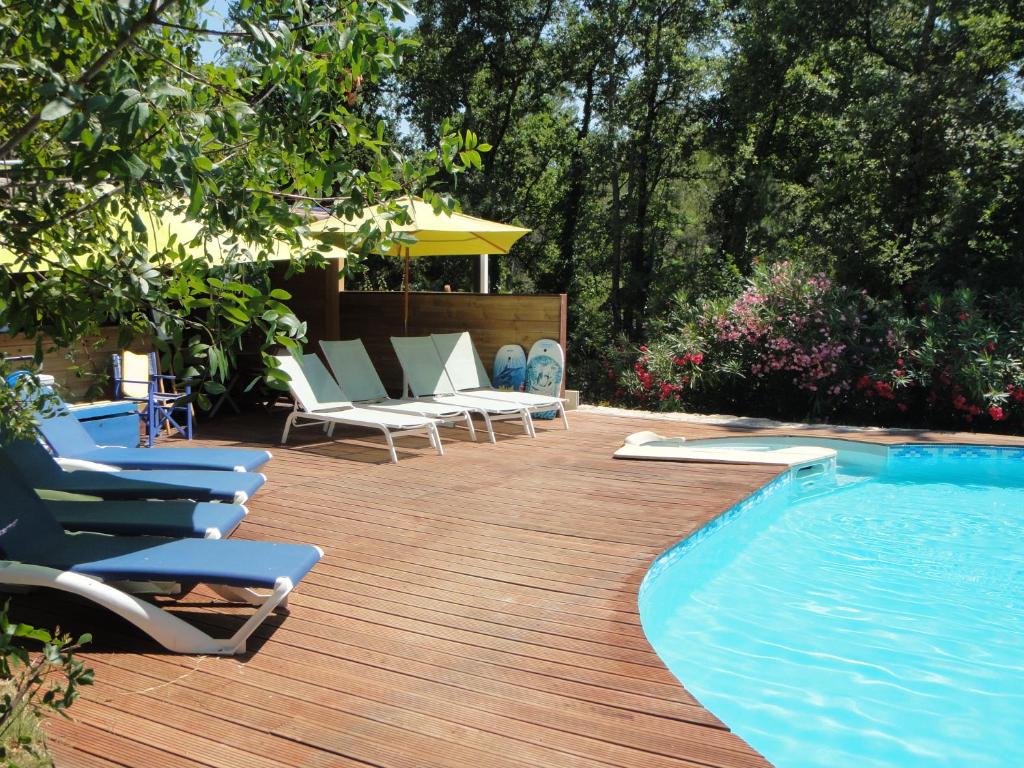 a deck with lounge chairs and a swimming pool at B&B L'Albatros in Fayence