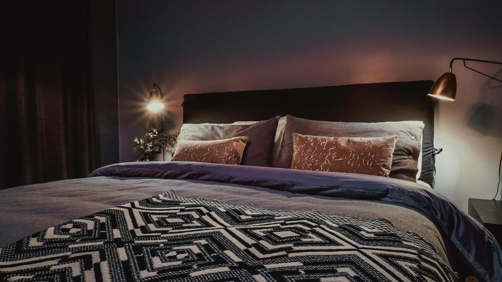 een slaapkamer met een groot bed met een deken en kussens bij Santa Teresita Boutique Hotel in San Fernando