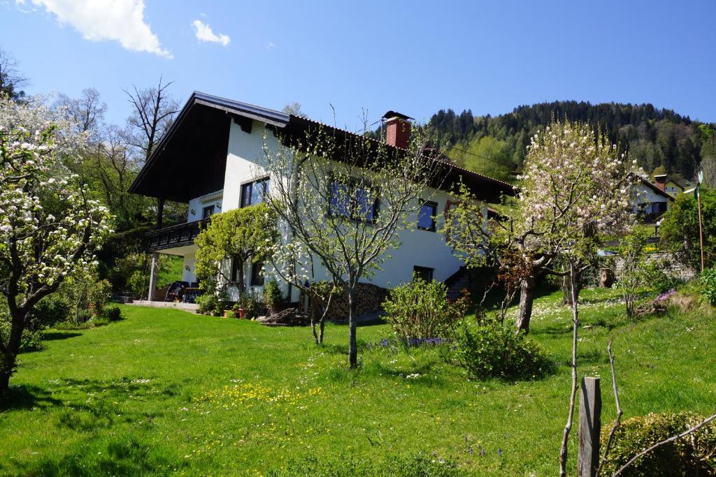 een huis met een tuin met bloeiende bomen ervoor bij Ferienwohnung am Dabor in Radenthein