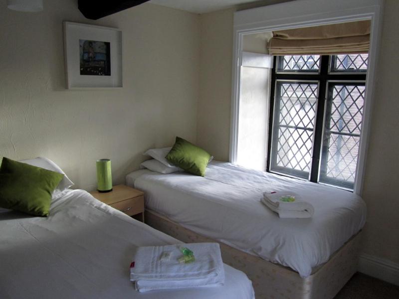 two beds in a room with a window at Queens Head Inn in Monmouth