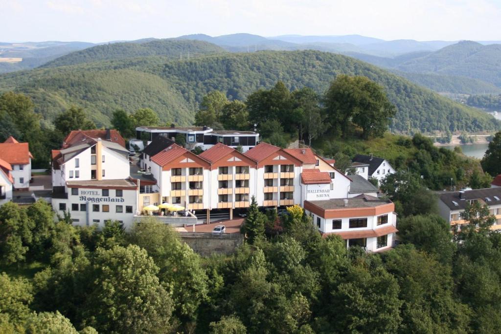 a group of buildings on a hill with mountains at Ringhotel Roggenland in Waldeck