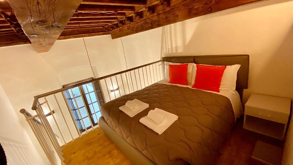 a bedroom with a bed with two red pillows at Santa Croce apt in Florence