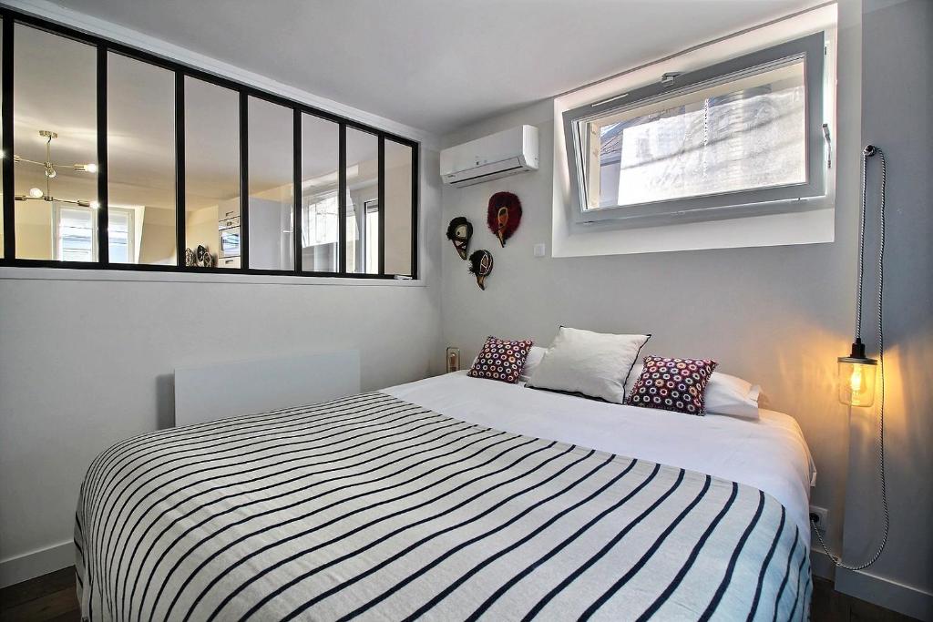 a bedroom with a bed with a black and white striped blanket at 102216 - Appartement 4 personnes Montorgueil in Paris