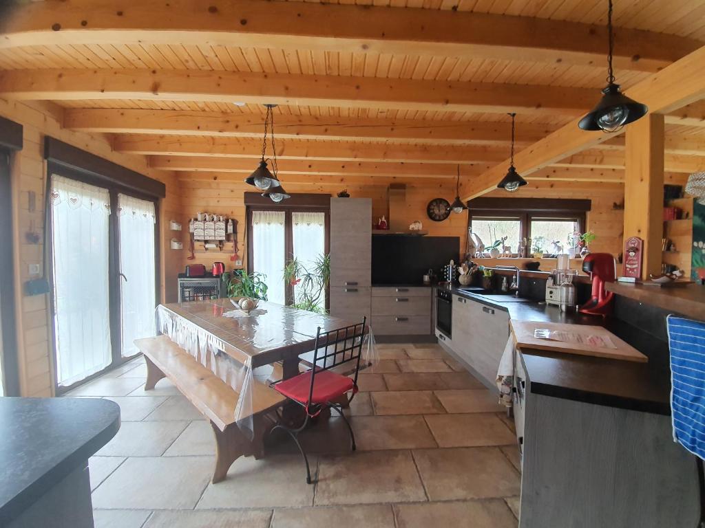 a kitchen with a wooden ceiling and a large table at Chalet du champs des semeaux in Wisches