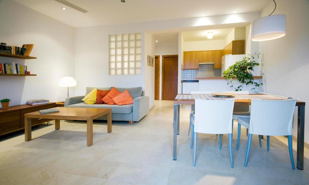 a living room with a couch and a table and chairs at Apartamentos Villamor in Denia