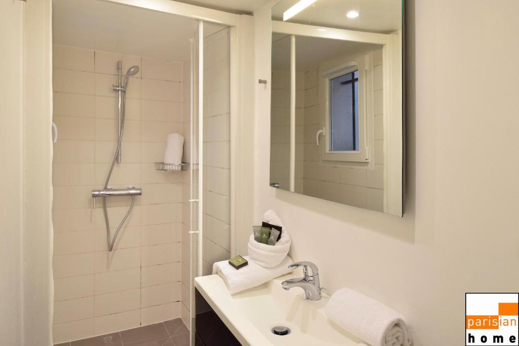 a bathroom with a sink and a shower with a mirror at 202419 - Elegant apartment for 6 people in the Montorgueil area in Paris