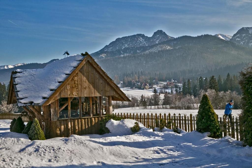 a log cabin in the snow with a fence at Pokoje u Uli in Kościelisko