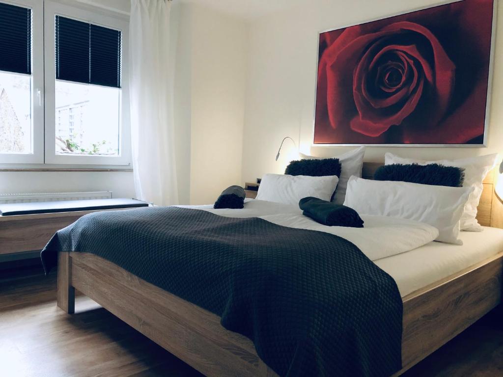 ein Schlafzimmer mit einem großen Bett mit einer roten Rose an der Wand in der Unterkunft Dolcevita in Bad Bertrich