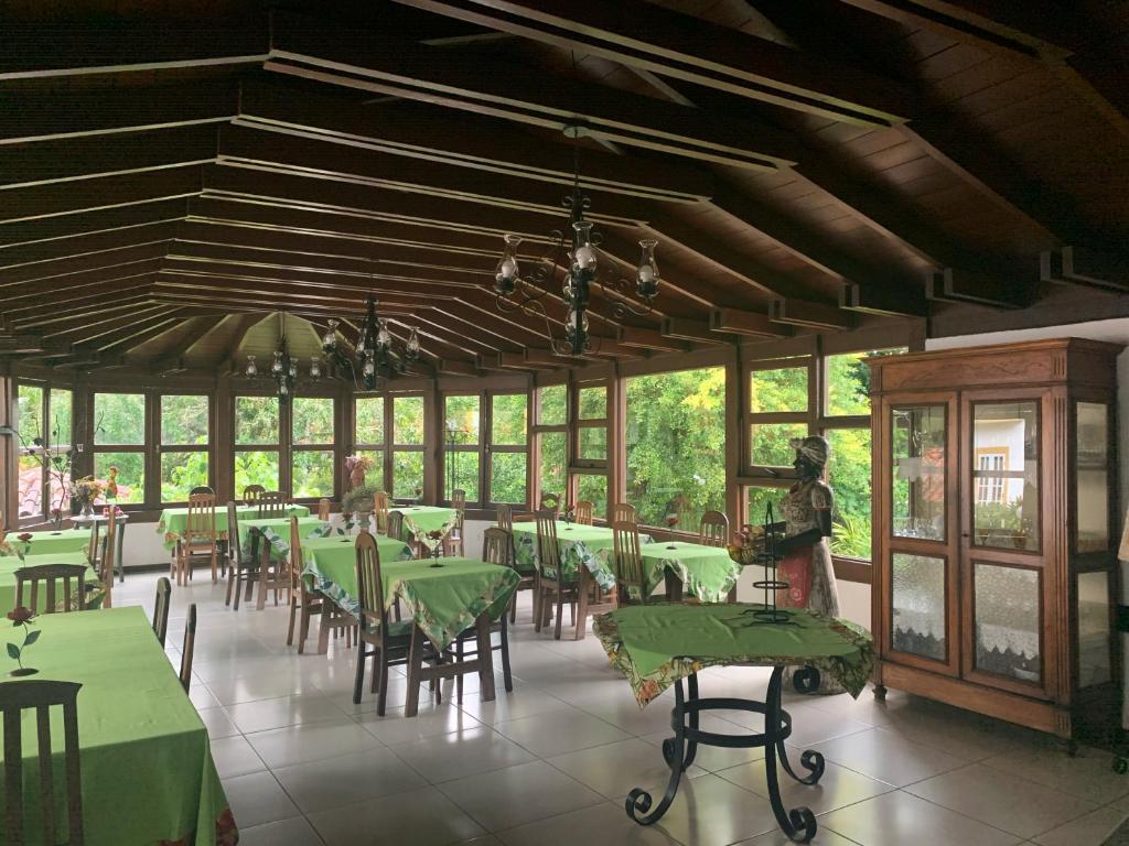 a dining room with green tables and chairs at Pousada Villa Real in Tiradentes