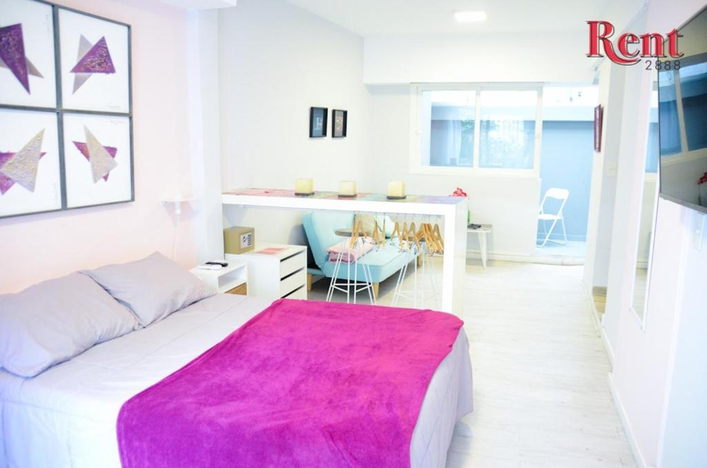 a white bedroom with a pink blanket on a bed at Rent Salguero in Buenos Aires