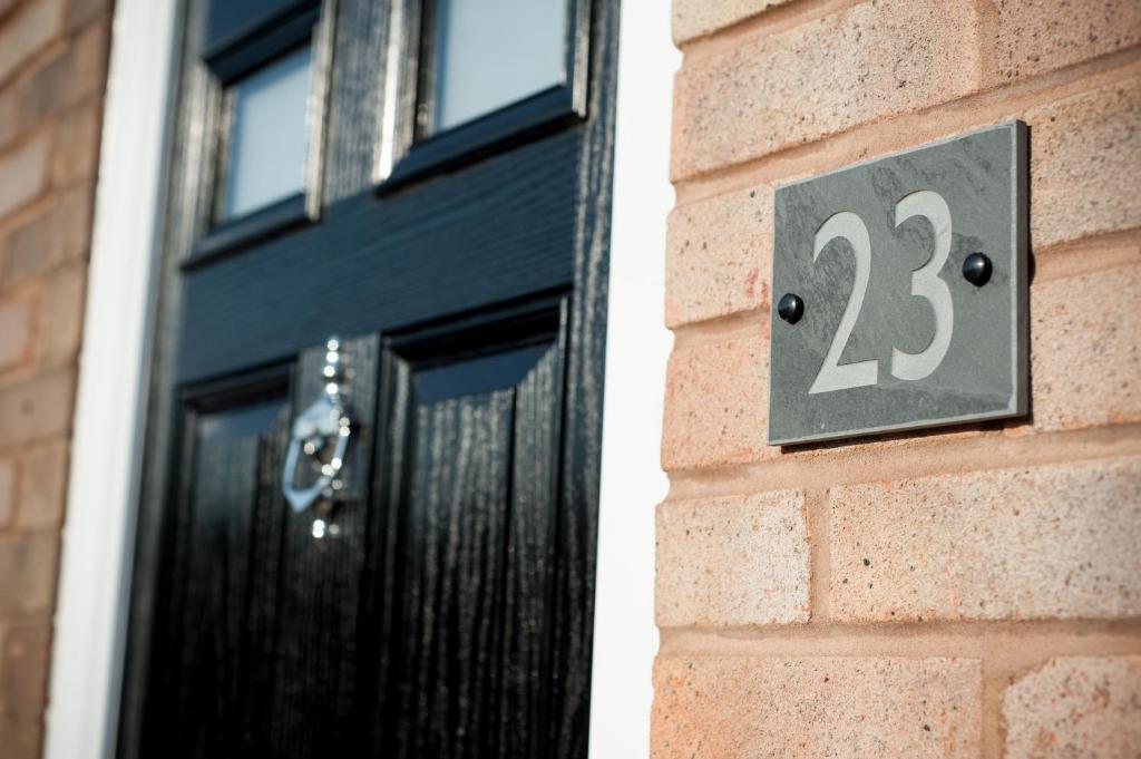 a black door with the number on a brick building at 'Modern Living in Old Town Stratford-upon-Avon' in Stratford-upon-Avon