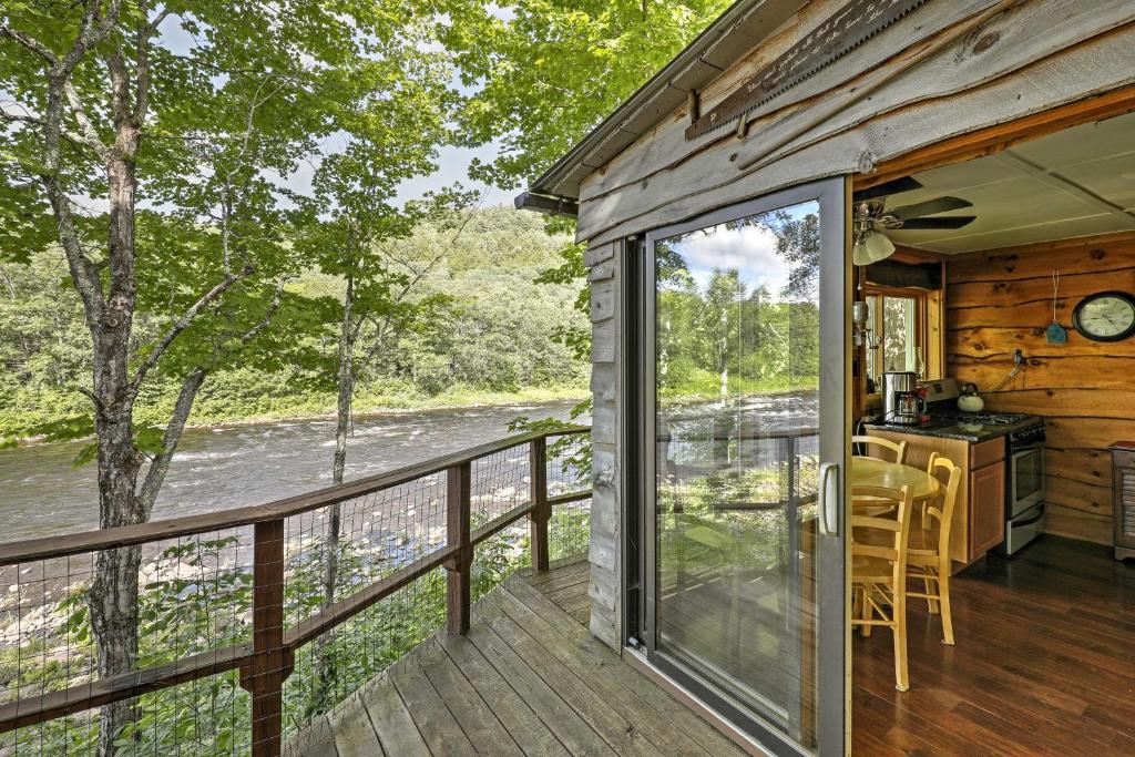 a screened in porch with a view of a river at Adirondack Mountains Cottage Near Gore Mountain! in Warrensburg