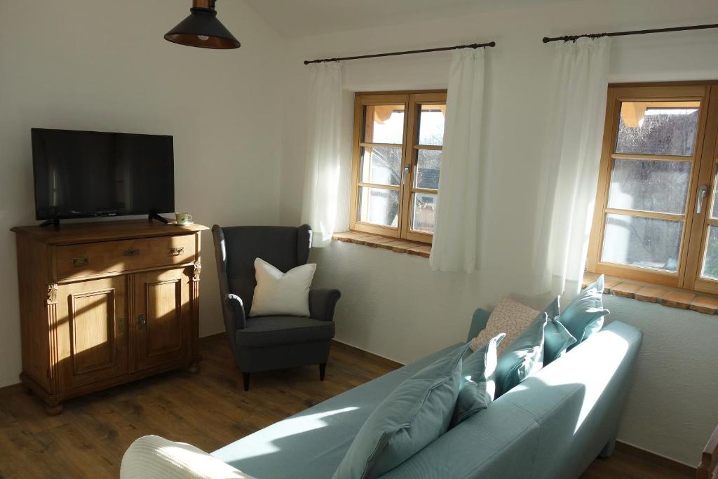 a living room with a couch and a television at Appartement - Ferienwohnung - FeWo Obernkammer in Emmering