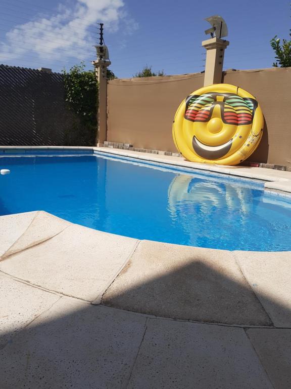 ein Schwimmbad mit einem großen gelben Vorbau eines Hauses in der Unterkunft Vistalba House in Ciudad Lujan de Cuyo