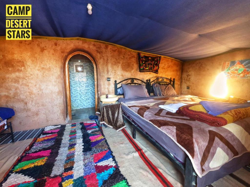 a bedroom with a large bed and a rug at Camp Desert Stars in Mhamid