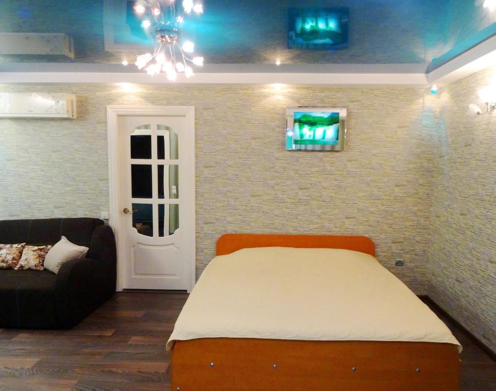 クロプィウヌィーツィクィイにあるApartのベッドルーム1室(ベッド1台、ソファ付)