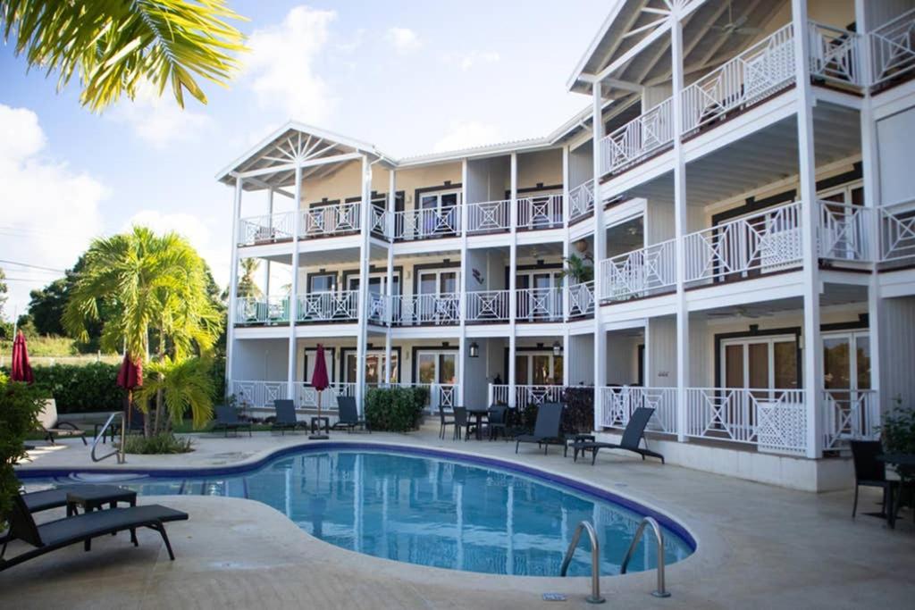 a hotel with a swimming pool in front of a building at Sea Glass Villa - Spacious 2 Bedroom, 2 Bathroom in Saint James