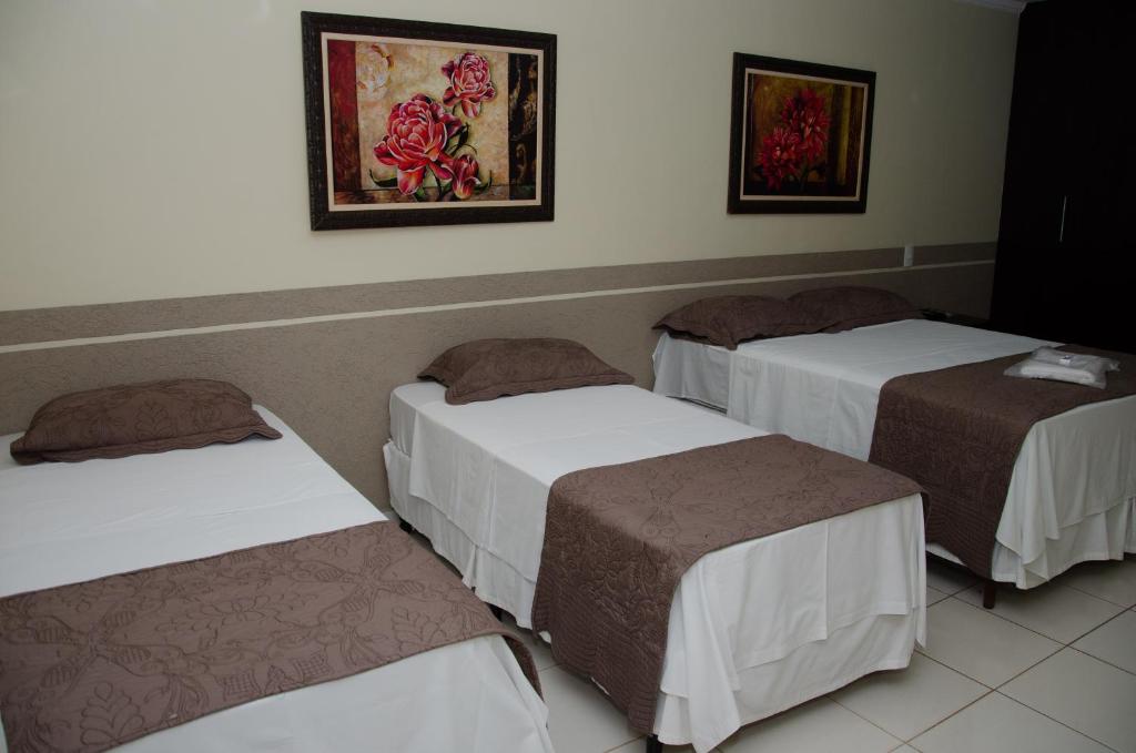 una habitación con tres camas en una habitación en Ilhabela Park Hotel, en Brasilia