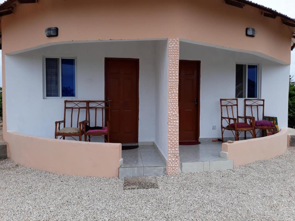 two chairs sitting on the porch of a house at Kinkiliba Beach Lodge in Sanyang