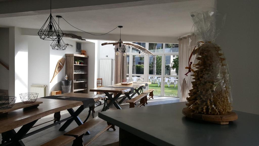 a dining room with tables and chairs and a large window at Les gîtes d'Aure in Vielle-Aure