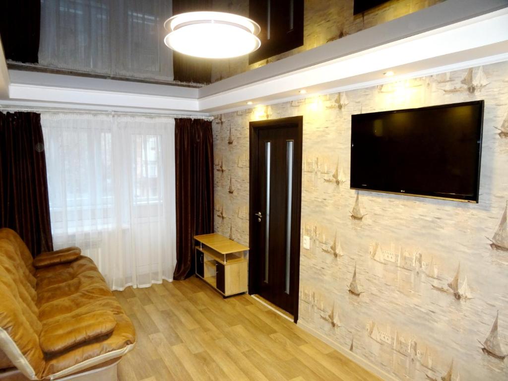 sala de estar con sofá y TV en una pared de piedra en Apartment en Kropyvnytskyi
