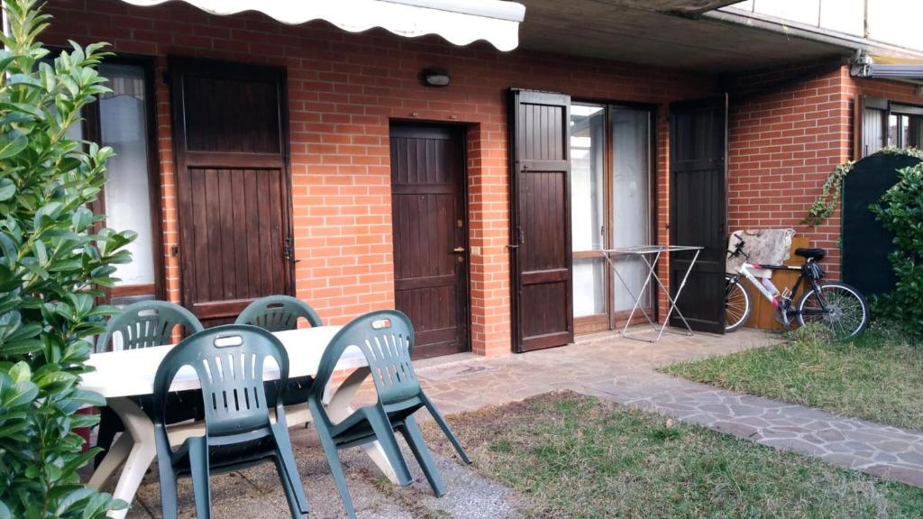 une table et des chaises devant une maison en briques dans l'établissement Villetta Rossini appartamento da CONDIVIDERE con me Luciano servizio ospiti taxi driver navetta no wifi 2 camera da letto per 5 persone, à Valbrembo