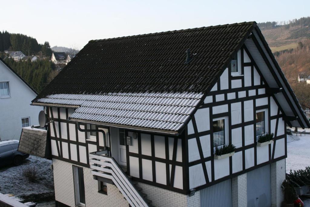 a black and white building with a roof at Ferienhaus Zur Ennest in Schmallenberg