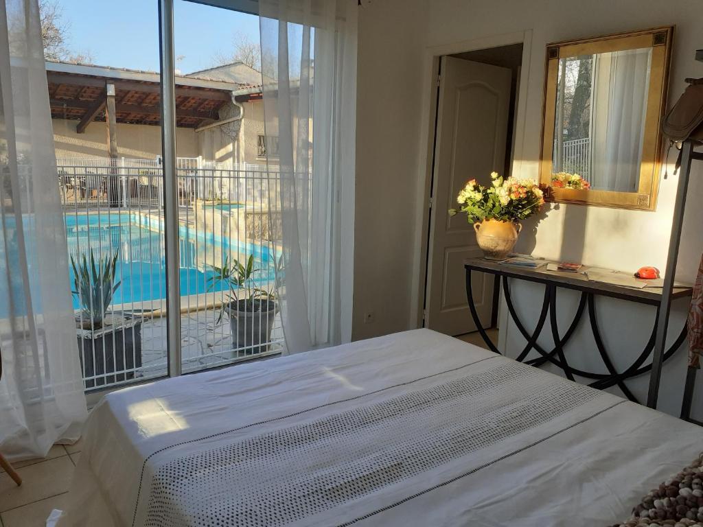 a bedroom with a bed and a view of a pool at La Bergerie in Lagarrigue